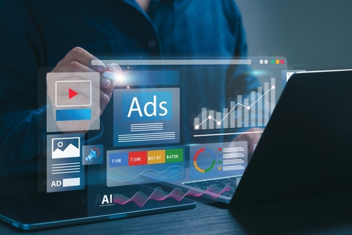 Person interacting with digital marketing analytics on a laptop, featuring ads, graphs, and AI elements, relevant to social media content strategies for 2025.